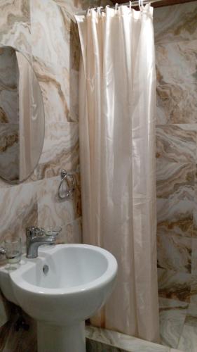 un bagno con lavandino e tenda da doccia di DaVinci Hostel a Yerevan