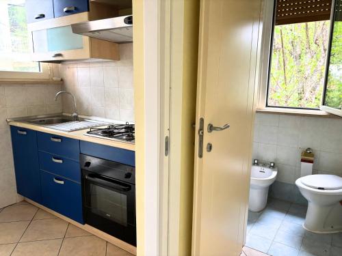 a small kitchen with blue cabinets and a toilet at M314 - Marcelli, comodo trilocale a 200mt dal mare in Marcelli