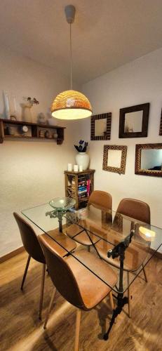 a dining room with a glass table and chairs at Les Flors !2minutos de la playa! in Lloret de Mar