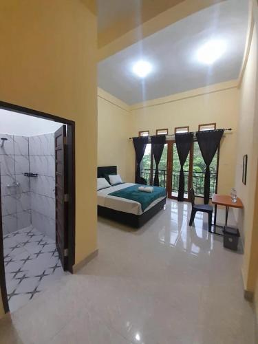 a bedroom with a bed and a shower in it at The Sanduk Inn in Rantepao