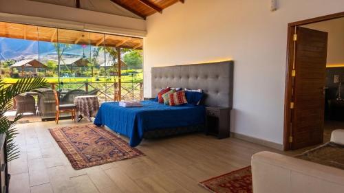 a bedroom with a blue bed and a balcony at Ranch Pachacamac in Pachacamac