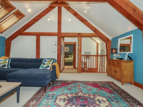 a living room with a blue couch and a rug at Pylemoor Cottage in Tiverton