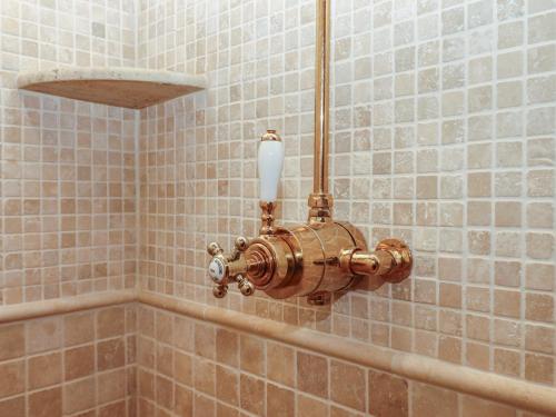 a bathroom with a copper fixture in a shower at Pylemoor Cottage in Tiverton