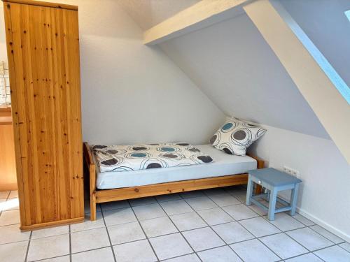 a small bedroom with a bed and a table at Buschhaus Whg 1 in Krummhörn