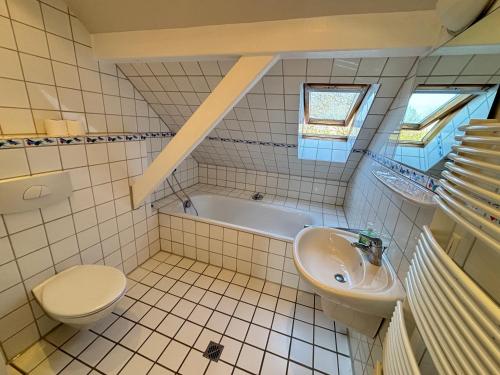 a bathroom with a sink and a toilet and a tub at Buschhaus Whg 1 in Krummhörn