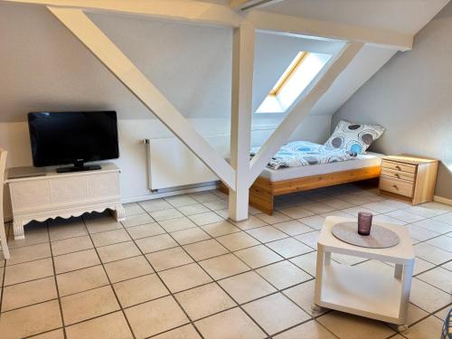 a small room with a bed and a tv at Buschhaus Whg 2 in Krummhörn