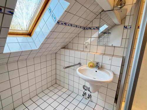 a bathroom with a sink and a skylight at Buschhaus Whg 2 in Krummhörn