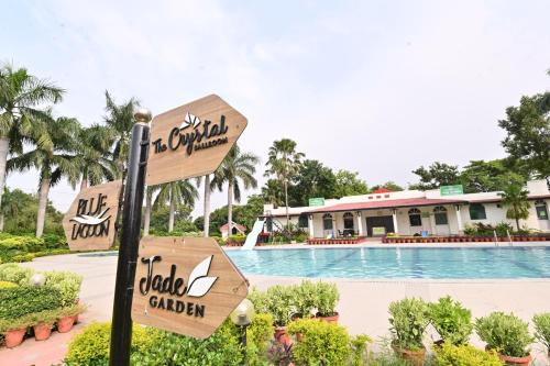 a sign at a resort with a swimming pool at Orient Resorts in Kānpur