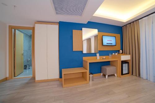 a room with a desk and a mirror on a blue wall at Downtown Sirkeci Hotel in Istanbul