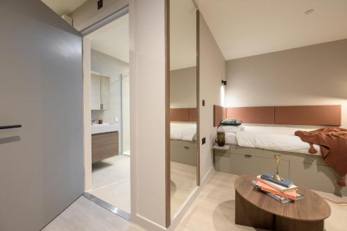 a small bedroom with a bed and a table at The Pepper Mill - Campus Residence in Edinburgh