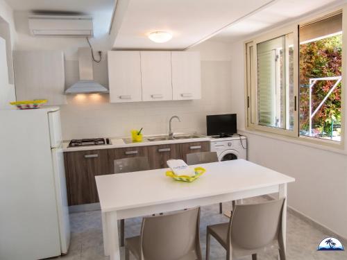 a kitchen with a white table and chairs at Le Fontanelle 2 in Fontanelle