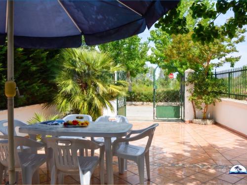 a table and chairs with an umbrella on a patio at Le Fontanelle 2 in Fontanelle