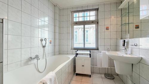 a white bathroom with a tub and a sink at Hotel zur Post in Bacharach