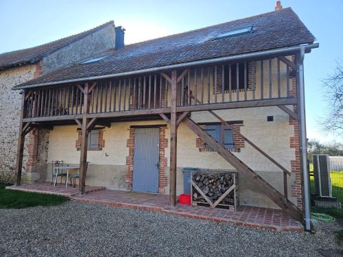 a building with a porch with a staircase on it at Nid de Coucou in Cernoy-en-Berry