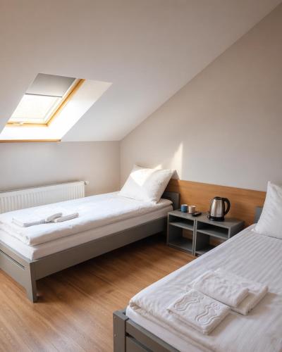 a bedroom with two beds and a skylight at Pokoje Noclegowe Sierpów in Sierpów