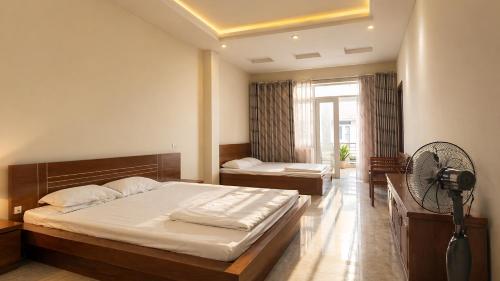 a bedroom with a large bed and a fan at RosePark Tuan Chau in Ha Long