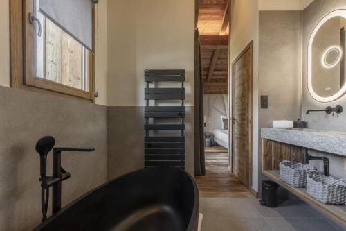 a bathroom with a black tub and a sink at Chalet Suzane - Panorama Mont-Blanc & jacuzzi in Combloux