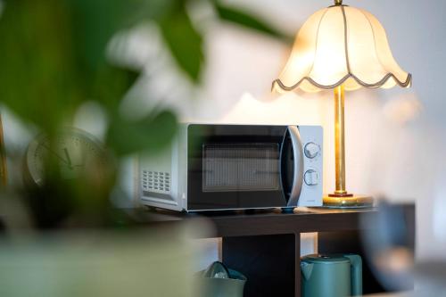a microwave and a lamp sitting on a table at NEW OPENING 2026 - Là di Maur - Appartamenti in Attimis