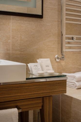 a bathroom with a counter with a sink and a mirror at UNA Hotels Decò Roma in Rome