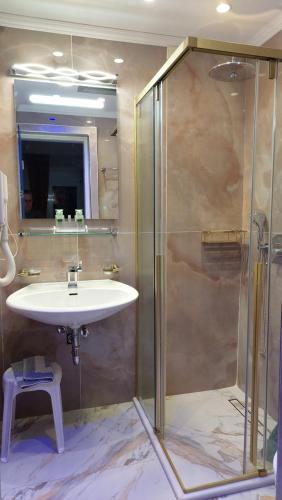 a bathroom with a sink and a shower at Hotel Astoria in Igoumenitsa