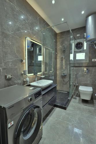 a bathroom with a washing machine and a toilet at A very, very special residential unit in Madinaty