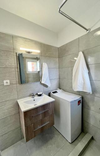a bathroom with a sink and a small refrigerator at Christiana's House in Artemida