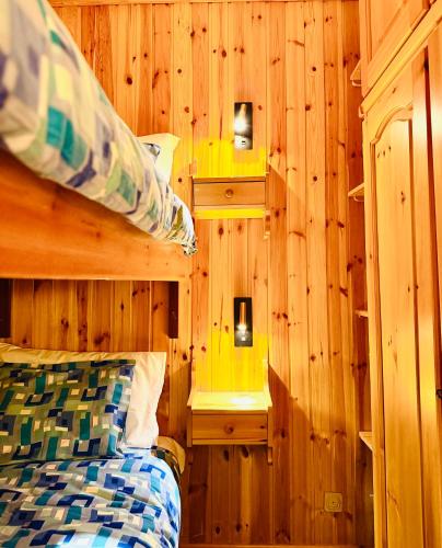ein Schlafzimmer mit Holzwänden und einem Bett in einem Zimmer in der Unterkunft Pila64 in Pila