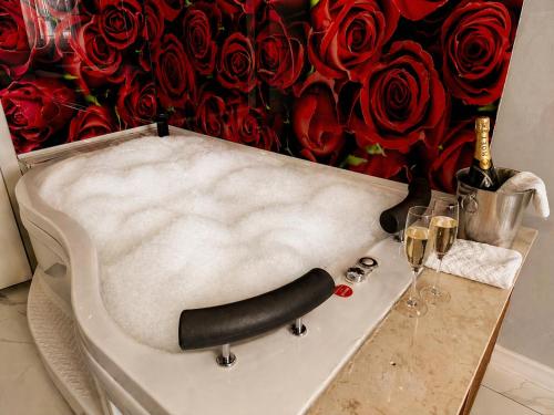 a table with a bottle of wine and a bunch of roses at Luka Suit Hotel in Istanbul