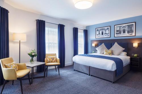 a hotel room with a bed and two chairs at Temple Bar Hotel Dublin by The Unlimited Collection in Dublin