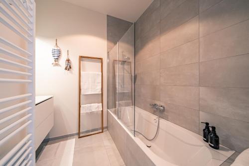 a bathroom with a shower and a tub at Top uitzicht luxe appartement DUNES met terras POOL & GYM in Ostend