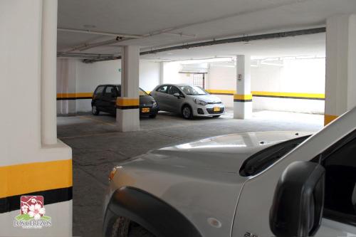 a parking garage with two cars parked in it at Apartahotel Los Cerezos in Neiva