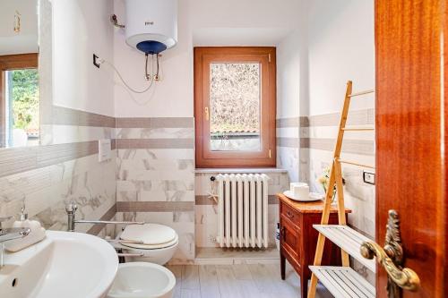 a bathroom with a sink and a toilet and a window at Nido della Rondine in Bagnoregio