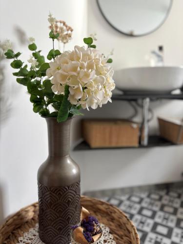 a vase with flowers in it on a table at Casinha da Aurora in Pedorido