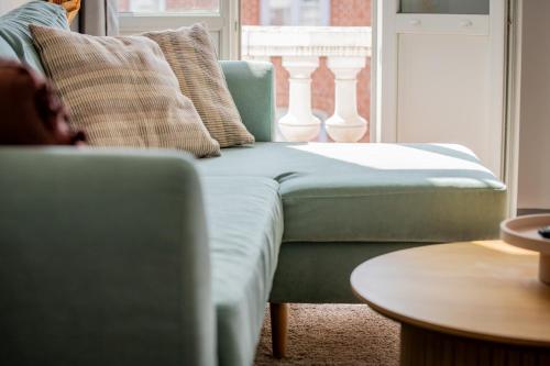 a green couch in a living room with a window at Perle de Liévin in Liévin