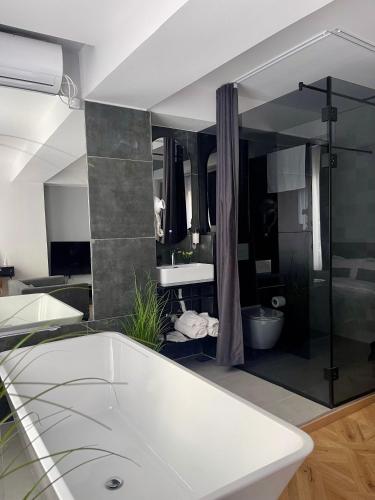 a bathroom with a white tub and a large mirror at XIX Boutique Apartment in Skopje