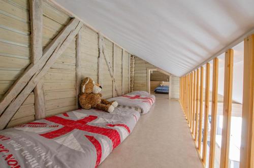 a row of beds in a room with a teddy bear at La cabriole des lacs in Briel-sur-Barse