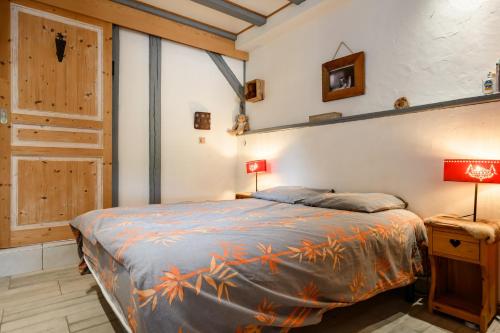 a bedroom with a bed and two lamps and a door at Gîte La Petite Maison Des Vacances in Kaysersberg