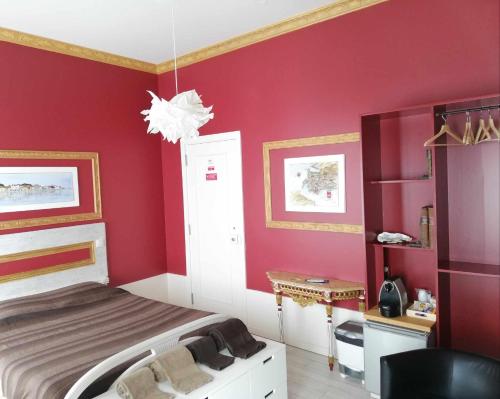 a bedroom with red walls and a bed at Legendary Bay - Suíte Temática in Seixal