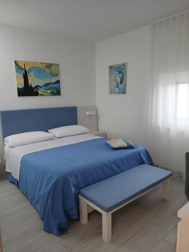 a bedroom with two beds with blue sheets and a bench at B&B Casaletto in San Nicola Arcella