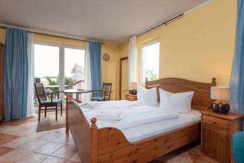 a bedroom with a large bed and a table with chairs at Dia Mare EG West in Ueckeritz