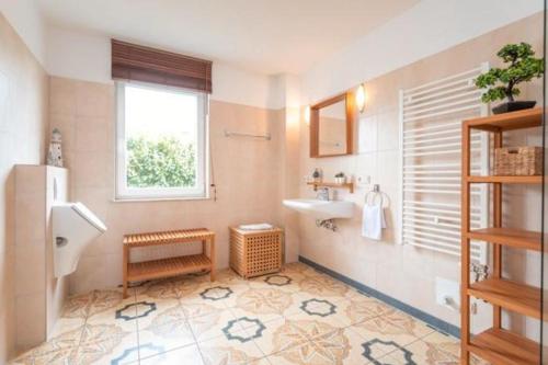 a bathroom with a sink and a toilet and a window at Dia Mare EG West in Ueckeritz