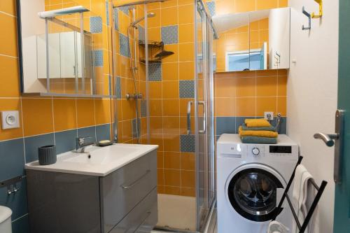 a bathroom with a washing machine and a sink at Le Marsalat - Lanton in Lanton