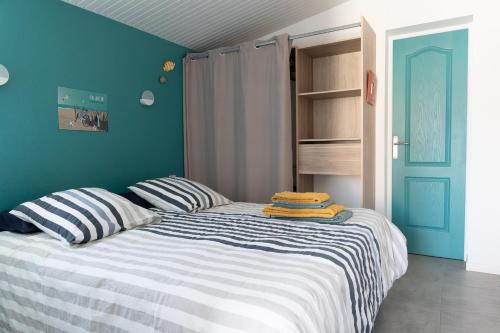 a bedroom with a bed with two pillows on it at Le Marsalat - Lanton in Lanton