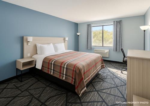 a hotel room with a bed and a window at Hotel Butler Inn in Butler