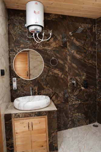 a bathroom with a sink and a mirror at Hotel Amadeus in Kanatal