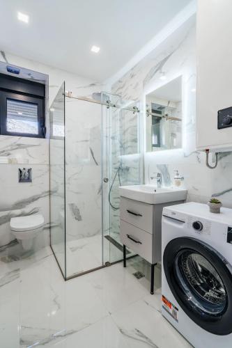 a white bathroom with a washing machine and a washer at Risan Bay in Risan