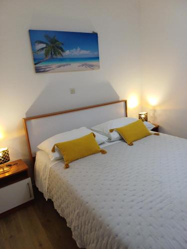 a bedroom with two beds with yellow pillows at Apartments Jure Miljak in Podstrana