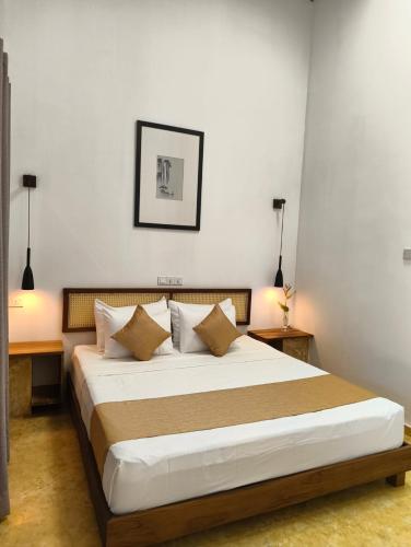 a bedroom with a large bed with pillows at Villa AyuSri in Ambalangoda