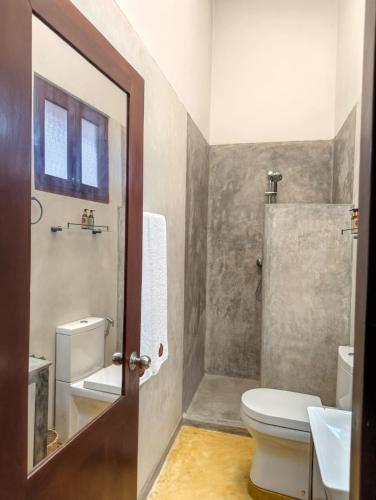 a bathroom with a toilet and a sink at Villa AyuSri in Ambalangoda