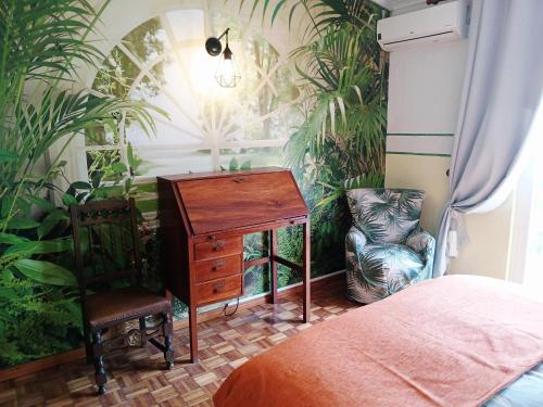 a bedroom with a desk and a chair and plants at Campo de Oleandros in Lourinhã